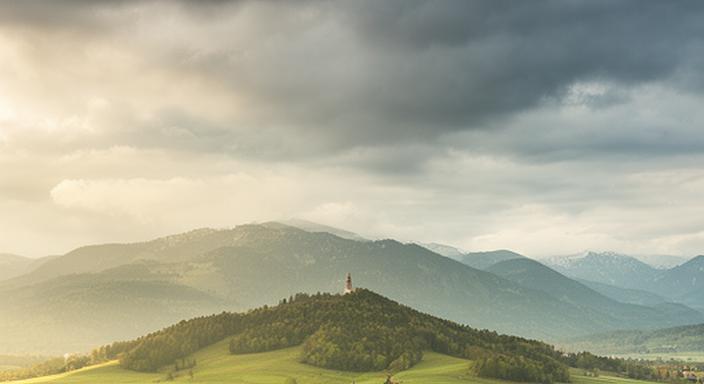 Blick auf Frauenstein in Kärnten mit sanften Hügeln und wechselhaftem Himmel – eine typische Wetterstimmung am Vormittag